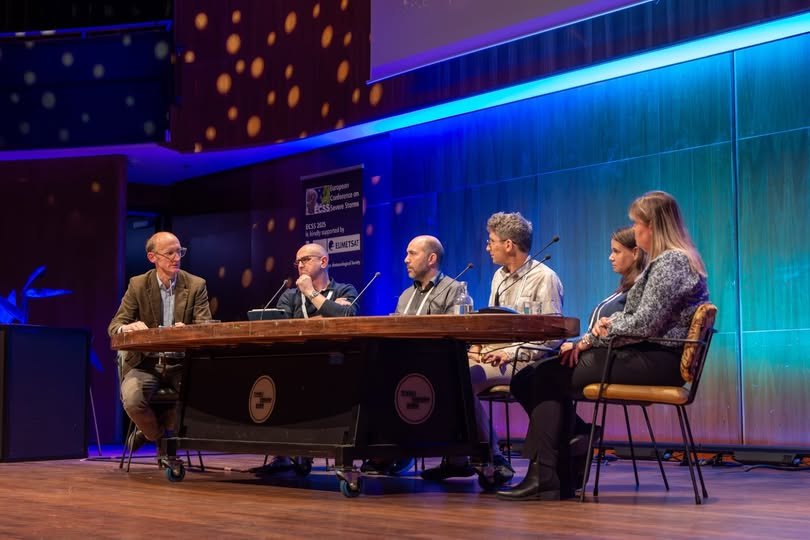 Six panellists seated at a long table on a stage with blue lighting during the Meteosat Third Generation panel discussion at ECSS 2025 in Utrecht